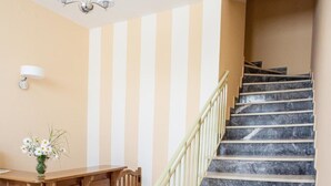 A staircase with marble steps and a wooden reception desk with a vase of flowers.