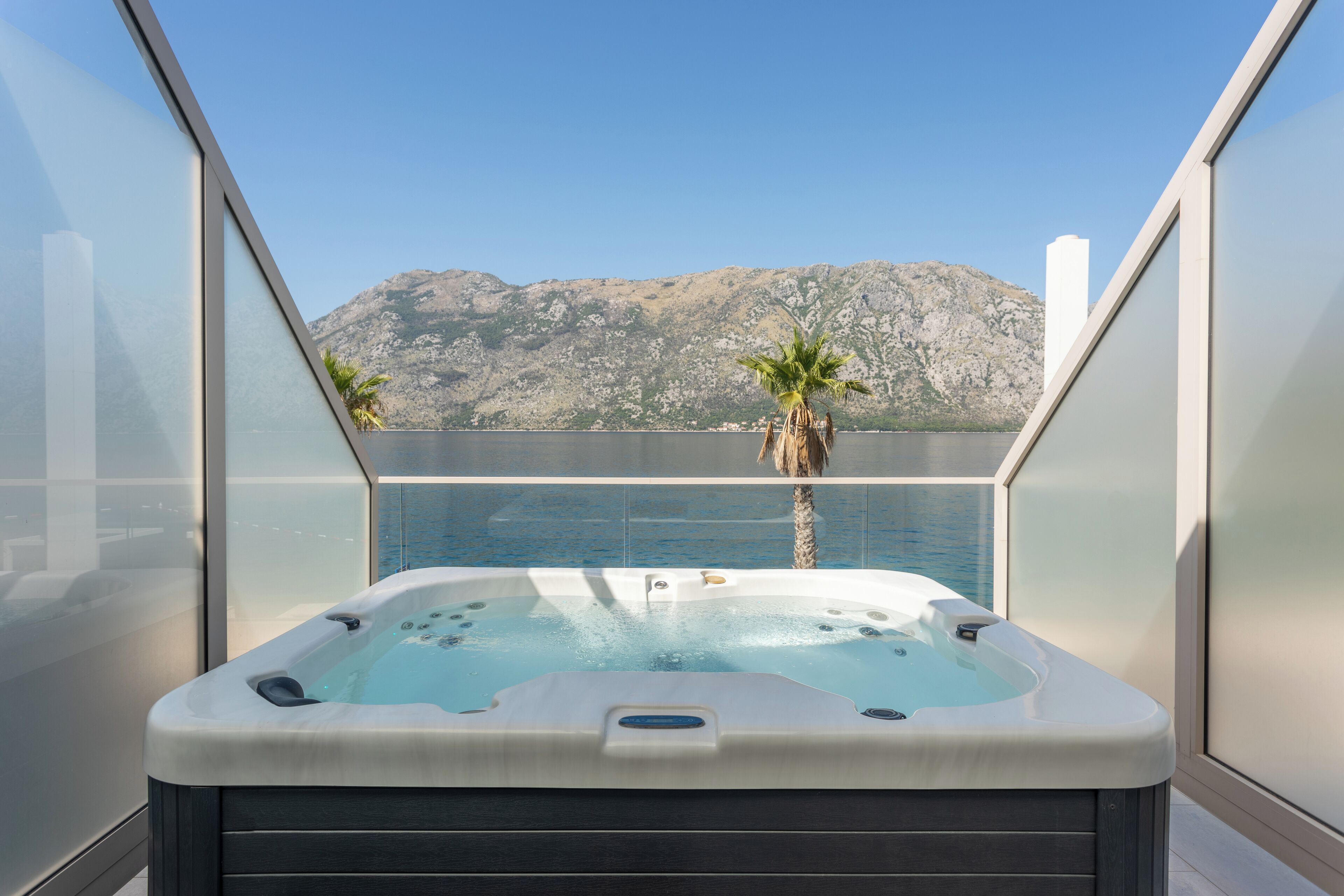 Un jacuzzi en un balcón con vistas a la montaña.