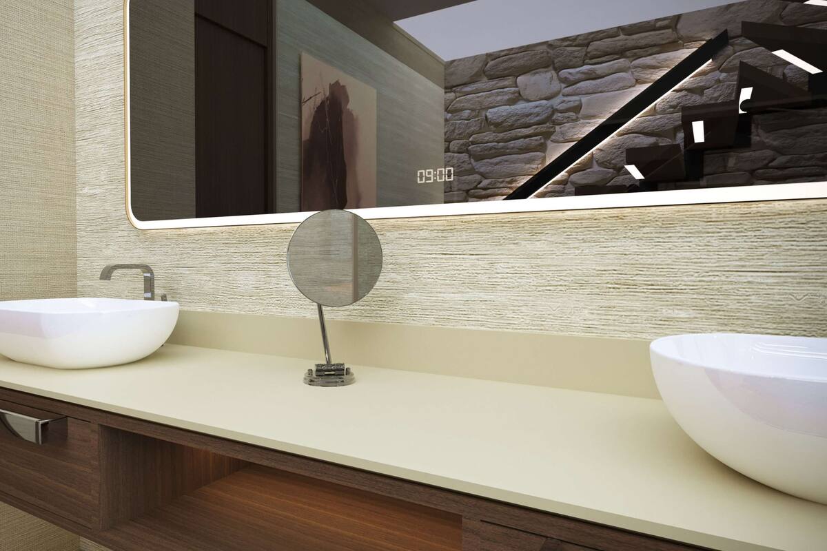 Une salle de bain avec deux vasques blanches, un miroir rond et un meuble-lavabo en bois.