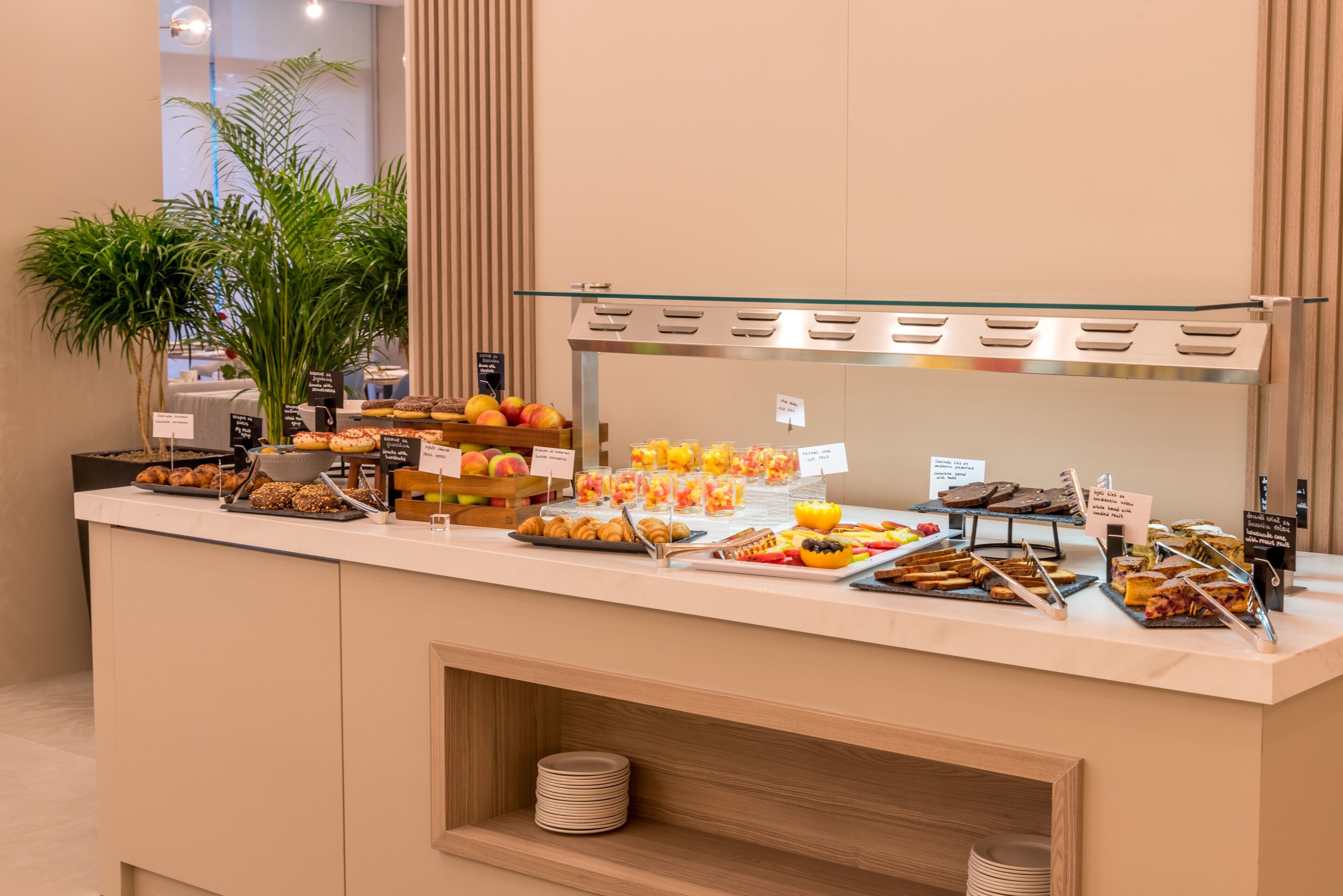 A buffet with various food items and a plant.