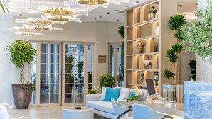 Un salon moderne comprenant un canapé, des fauteuils, une table basse et une bibliothèque.