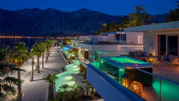 Un hôtel moderne doté d'une piscine, d'un espace extérieur aménagé et offrant une vue sur les montagnes.