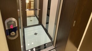 An elevator with a glass door, a digital display, and a metallic interior. - He Yi B&B (Luodong)