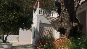 Un chemin de pierres mène à un bâtiment blanc doté d’un balcon.