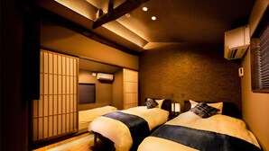 A hotel room with two beds, wooden flooring, and traditional Japanese sliding doors. - SKY Kyoto (Kyoto)