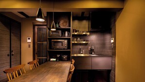 A compact kitchen with a wooden dining table, built-in appliances, and a small countertop. - SKY Kyoto (Kyoto)