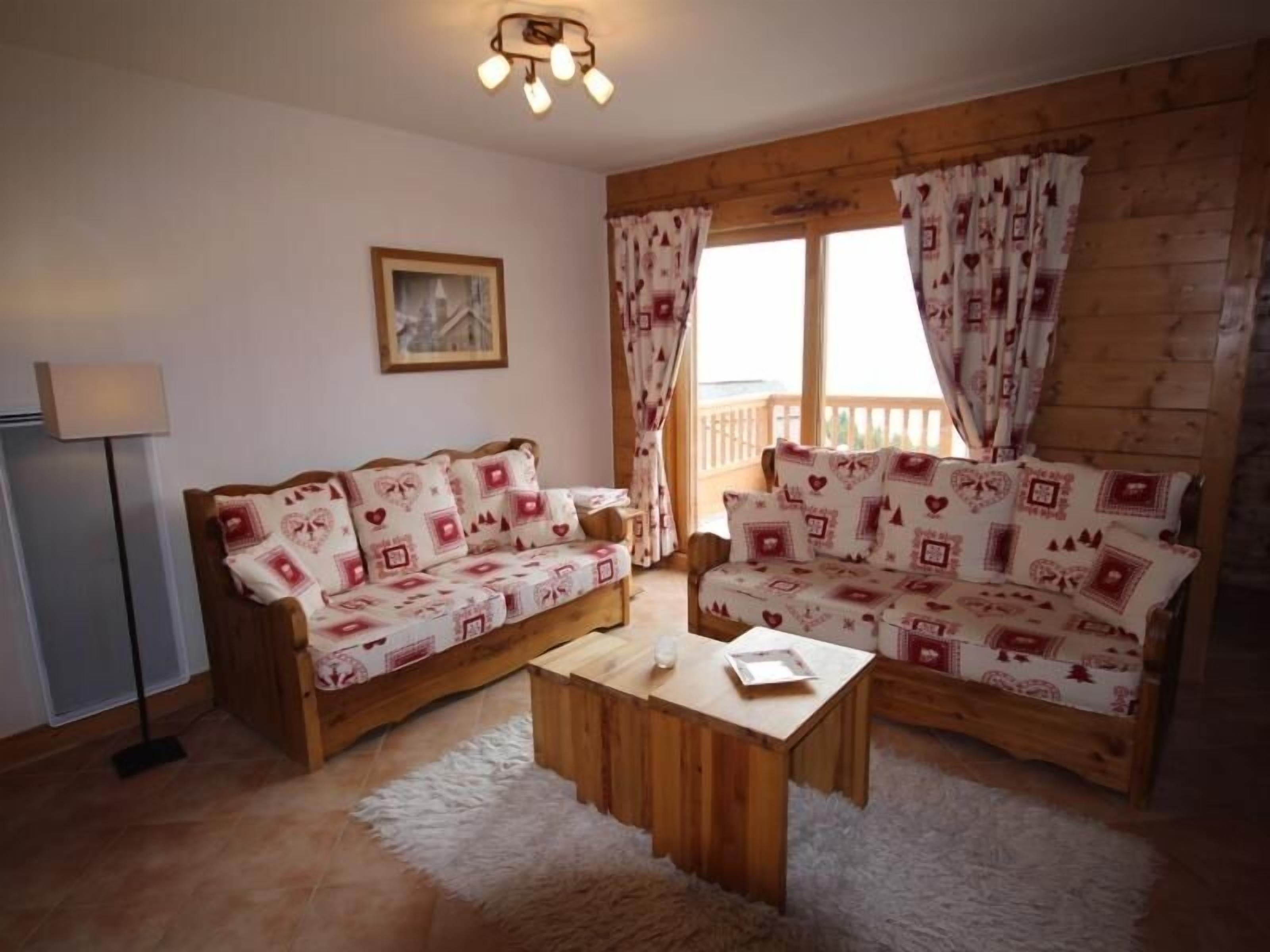Un salon chaleureux avec deux canapés en bois, une petite table basse en bois et un tapis moelleux.