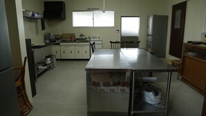 A compact kitchen with a central island, a microwave, a sink, and cabinets. - Syouyayasikitokura (Kasaoka)