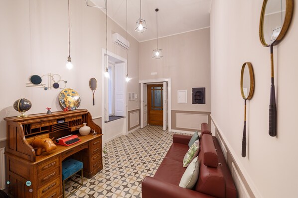 A room with a wooden desk, a red typewriter, a globe, and a patterned floor. - B&B Le Chiavi Di Casa (Naples)