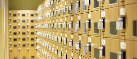 A row of gold-colored lockers with numbered labels, indicating a storage or locker room area.