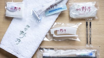 A towel, a shower cap, a comb, and a toothbrush set on a wooden surface.