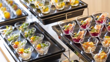 Buffet com diversos alimentos dispostos em bandejas.