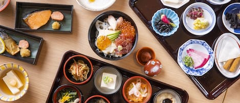 Eine Auswahl an Gerichten auf einer Platte, darunter Sushi, Sashimi und weitere japanische Spezialitäten.