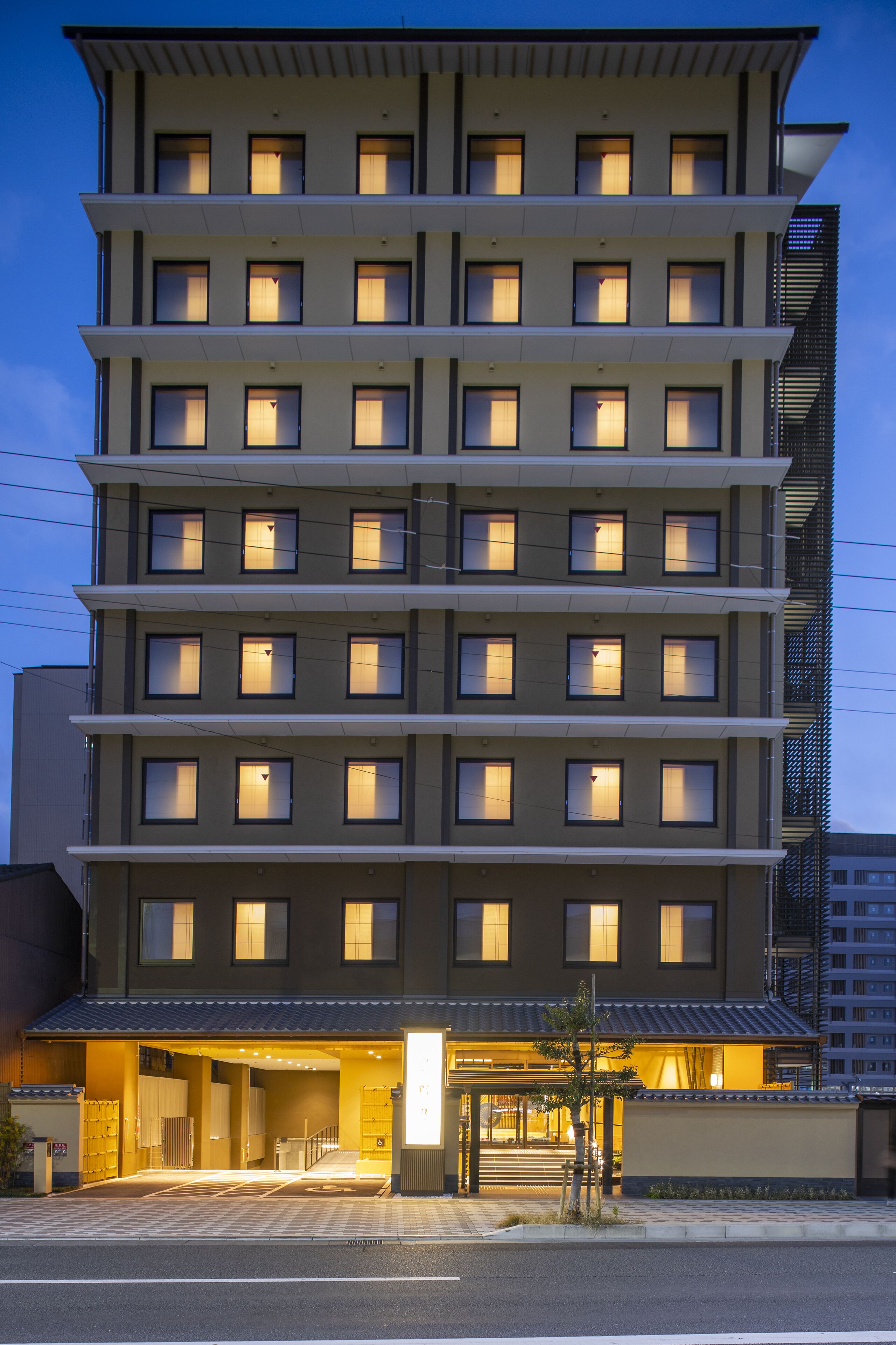 A multi-story hotel with a modern design, featuring a central entrance and multiple windows on each floor.