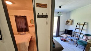 Ein Zimmer mit einem Bett, einem Fernseher, einer Couch und einem kleinen Tisch.