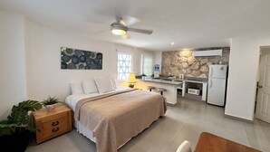 A compact hotel room with a bed, bedside table, and a small kitchenette. - COZY STUDIO WITH FULL KITCHEN ★ AMAZING LOCATION (Cancún)