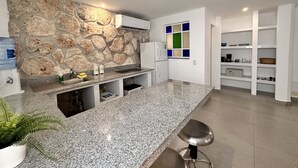 A modern kitchen with granite countertops, a stone accent wall, white cabinetry, and a built-in oven. - COZY STUDIO WITH FULL KITCHEN ★ AMAZING LOCATION (Cancún)