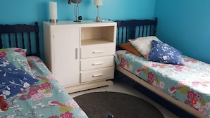 Ein Zimmer mit zwei Betten, einem Schminktisch, einem Spiegel und einem Bild an der Wand.
