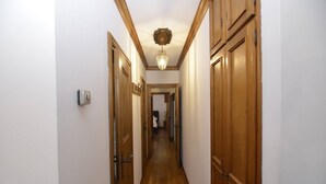 A narrow hallway with wooden doors and a light fixture on the ceiling. - Punta Nera Apartment: WI-FI and garden. (Cortina d´Ampezzo)