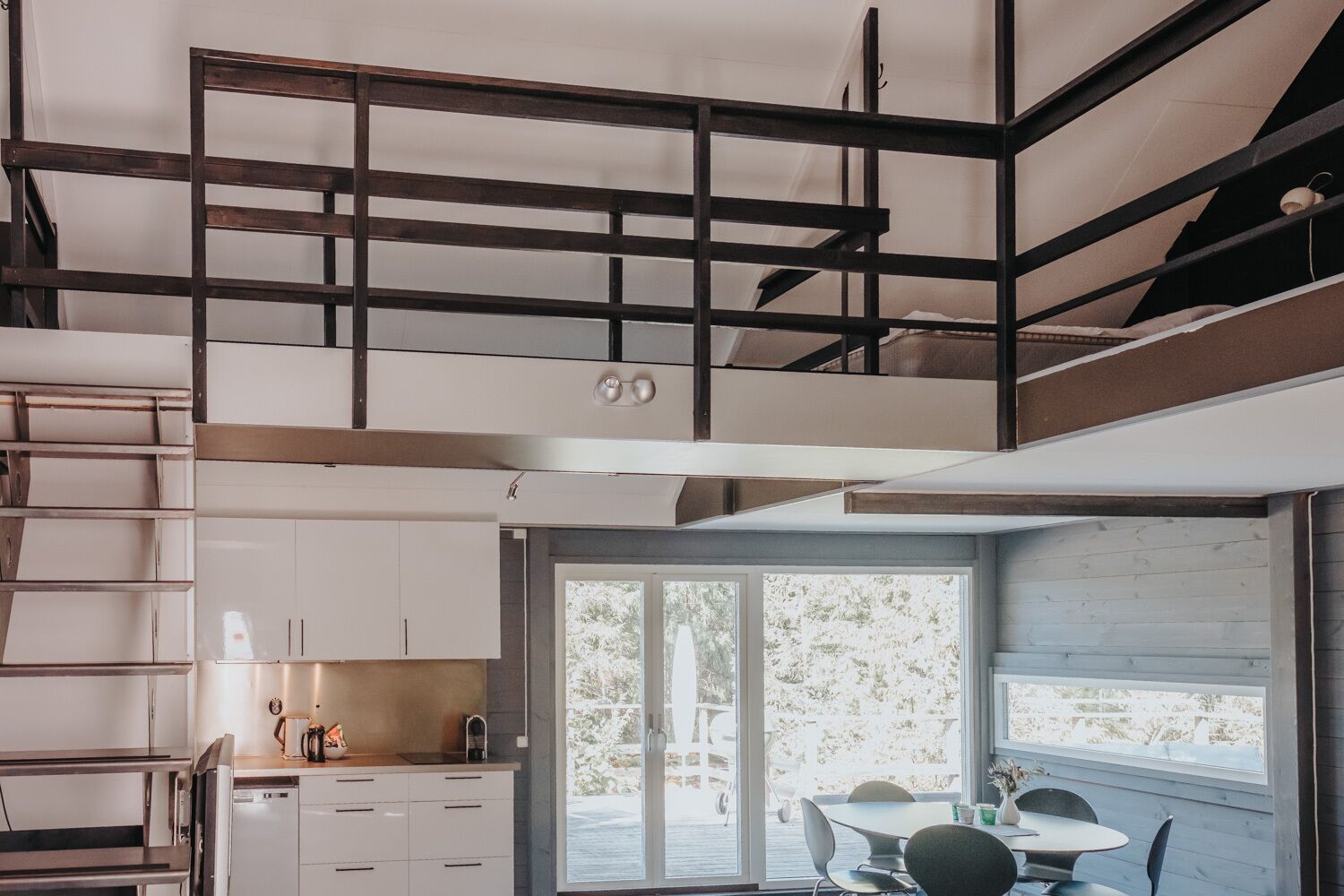 Un apartamento moderno estilo loft con cocina, comedor y un balcón con vistas al exterior.