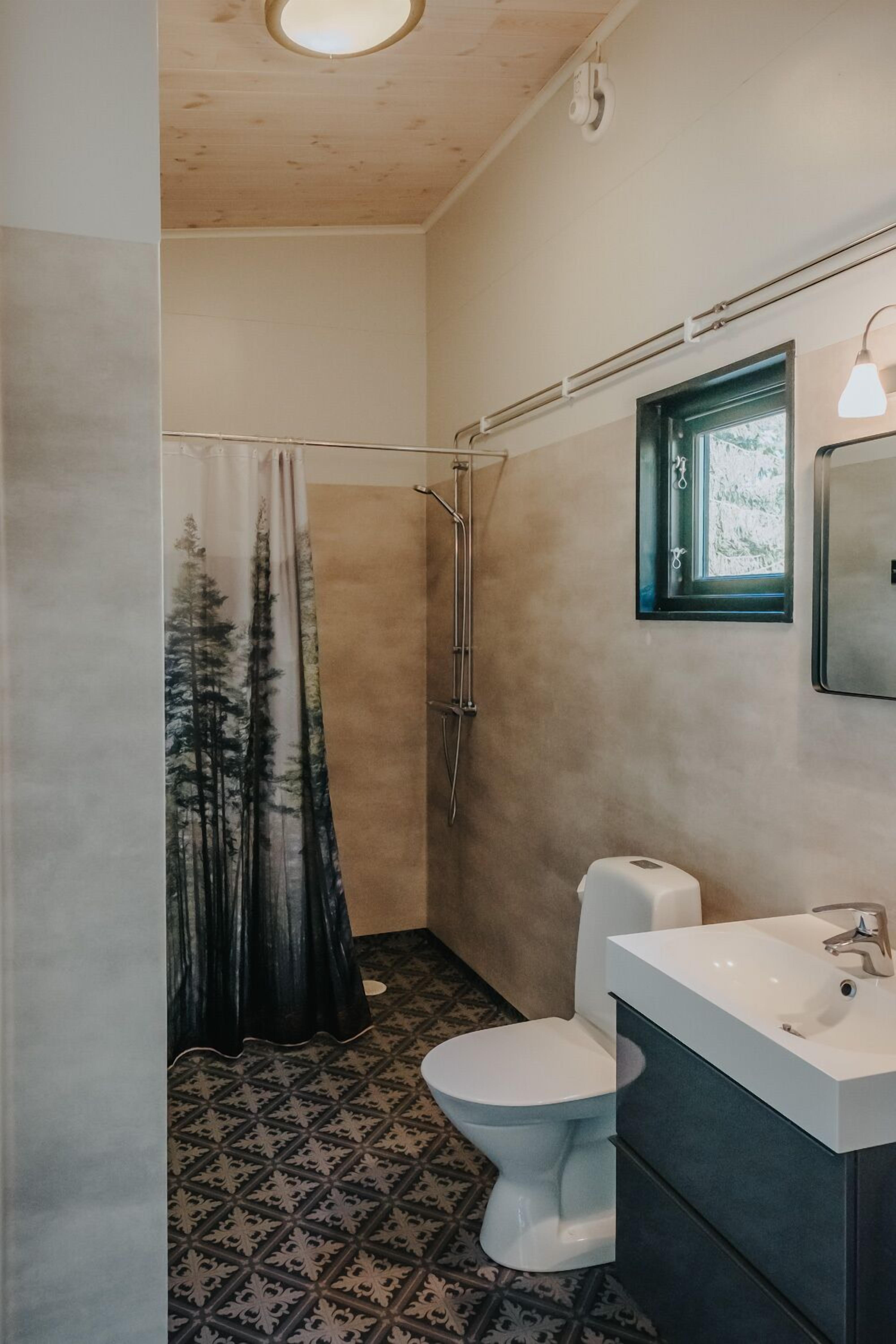 A bathroom with a shower, toilet, and sink.