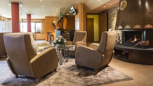 Un salón moderno con asientos cómodos, chimenea y televisor montado en la pared.