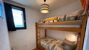 A bunk bed with a window and a hanging light fixture. - Cozy 2-room apartment, 5 people, Les Saisies (Les Saisies)