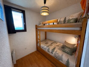 A bunk bed with a window and a hanging light fixture. - Cozy 2-room apartment, 5 people, Les Saisies (Les Saisies)