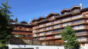 A multi-story hotel with balconies, a ski lift, and a parking area. - Renovated 2BR apartment at ski slopes with parking - Courchevel 1850 (Courchevel 1850)