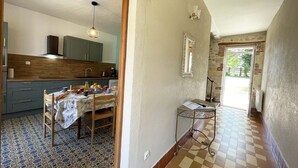 A kitchen with a dining table, a small side table, and a mirror on the wall.