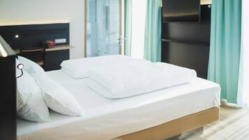 Un lit bien fait, avec du linge de lit blanc, dans une chambre d'hôtel.
