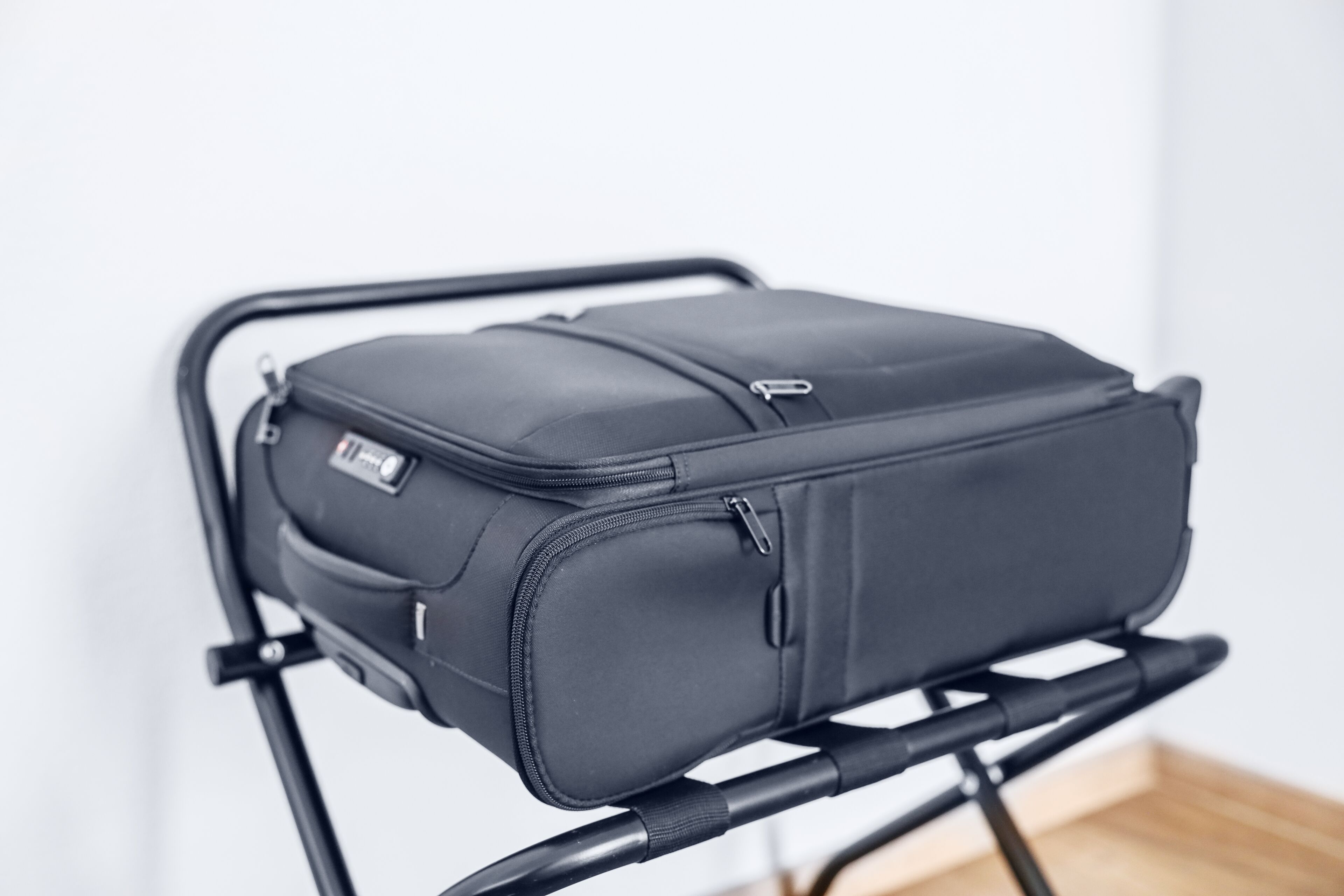 A black suitcase on a black luggage trolley.