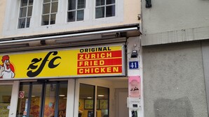 En butik med et skilt, der viser 'Original Zurich Fried Chicken'.