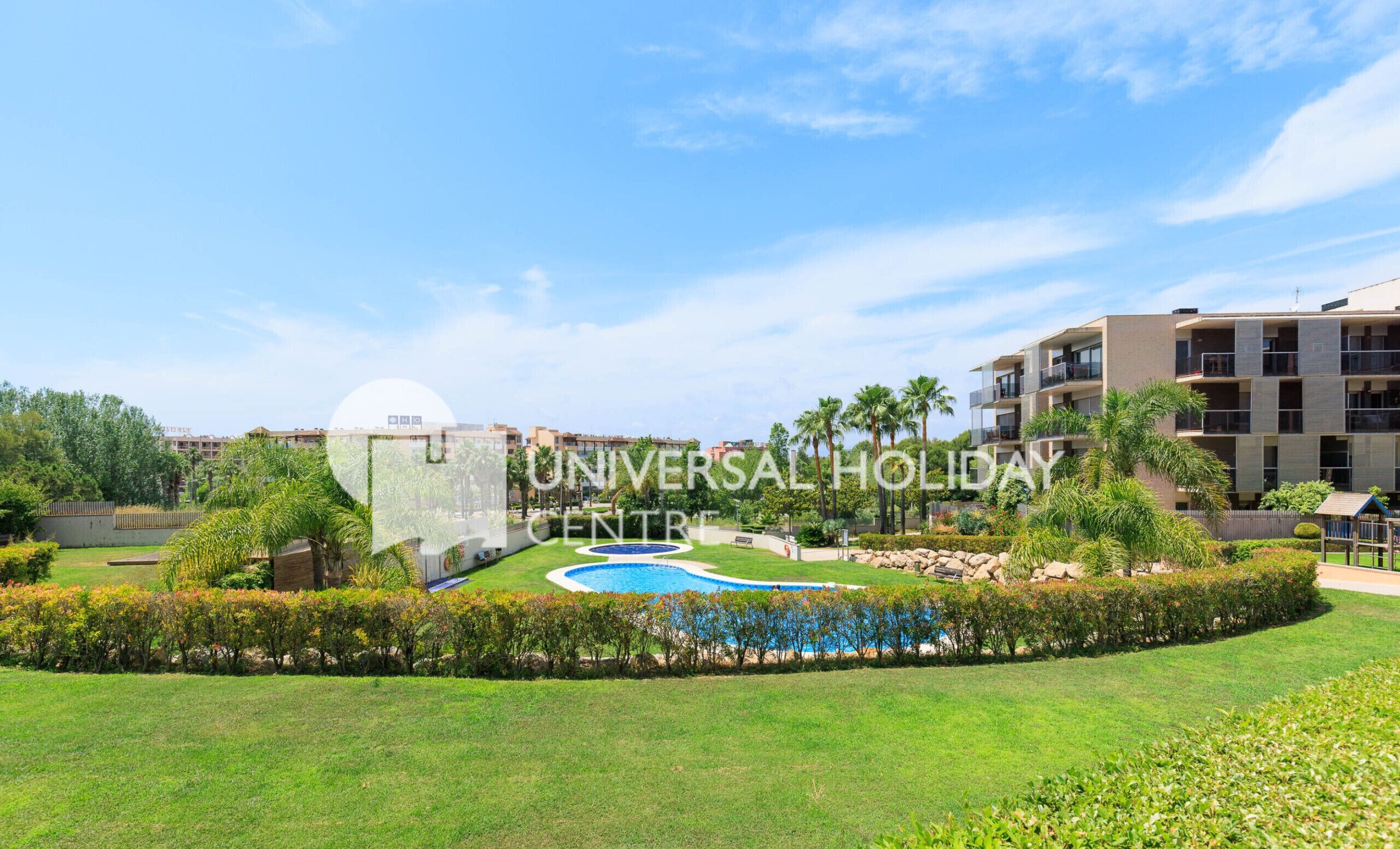 Un resort con piscina, abundante vegetación y edificios modernos.