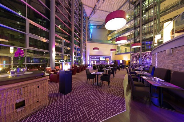 Amplio espacio interior con diversas opciones de asientos, una zona de bar y un gran techo iluminado.
