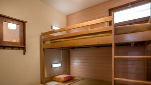A bunk bed room with a wooden frame, a small bedside table, and a window with blinds. - Cozy studio for 4, near Val d'Isère center, with WIFI (Val-d'Isère)