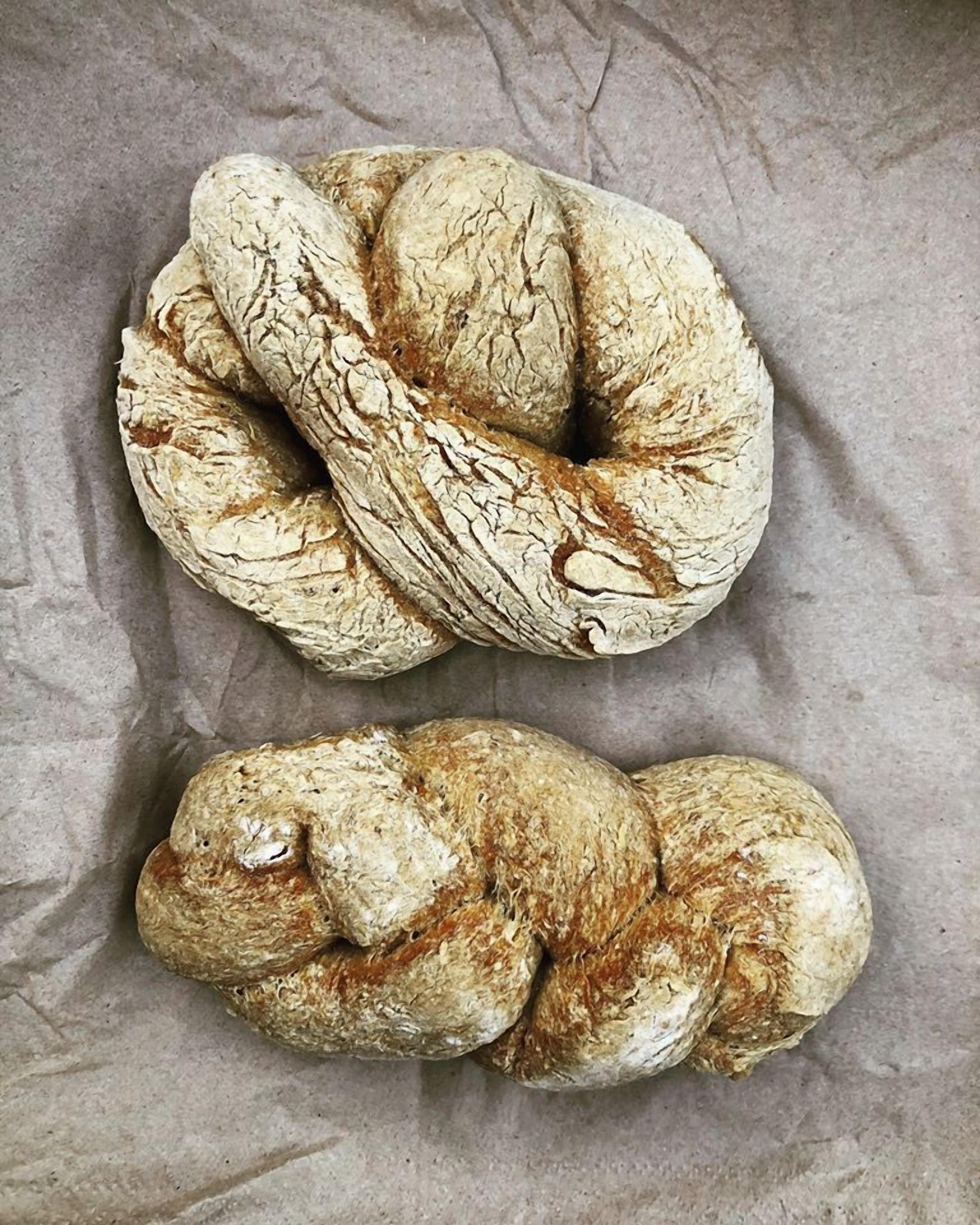 Dos hogazas de pan trenzado sobre una superficie rugosa.