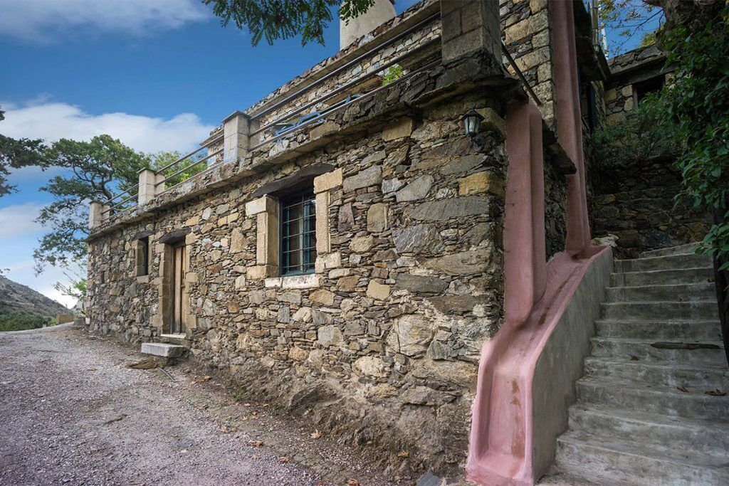 Un bâtiment en pierre avec un escalier menant à un balcon.