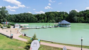 A lakeside park with a gazebo, a small building, and a dock extending into the water. - Bagoly Fogadó (Gyomro)