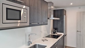 A modern kitchen with a built-in microwave, stainless steel sink, and a coffee maker. - Costa Azul - 3 Left (Puerto de Naos)
