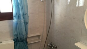 A bathroom with a shower, toilet, sink, and a towel rack. - Villa Perris Studios (Corfu)