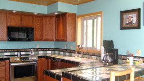 Une cuisine avec des meubles en bois, une cuisinière en acier inoxydable, un four à micro-ondes et une fenêtre donnant sur un beau paysage.