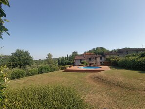Relax in a serene outdoor space surrounded by lush greenery and a pool.