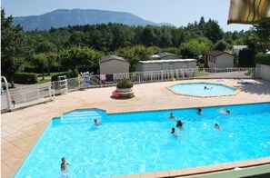 Una piscina al aire libre de temporada, sombrillas, tumbonas