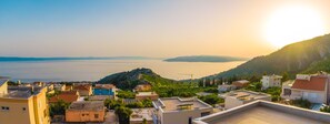 A coastal town with buildings on a hillside overlooking a calm sea. - Sun Spalato Villas (Makarska)