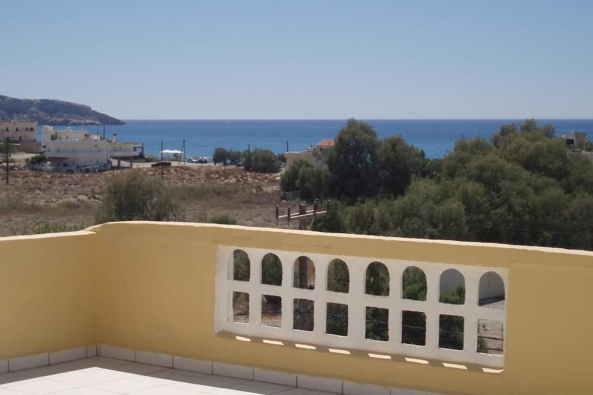 Un balcón con vista al mar y una costa lejana.