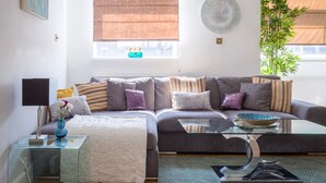 Ein modernes Wohnzimmer mit Sofa, Couchtisch und einer Topfpflanze.