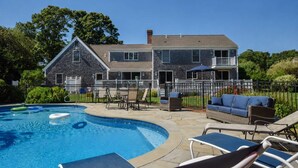 A residential property with a swimming pool, outdoor furniture, and a two-story house. - Beautiful Spacious Family Retreat w/ Pool! (Eastham)