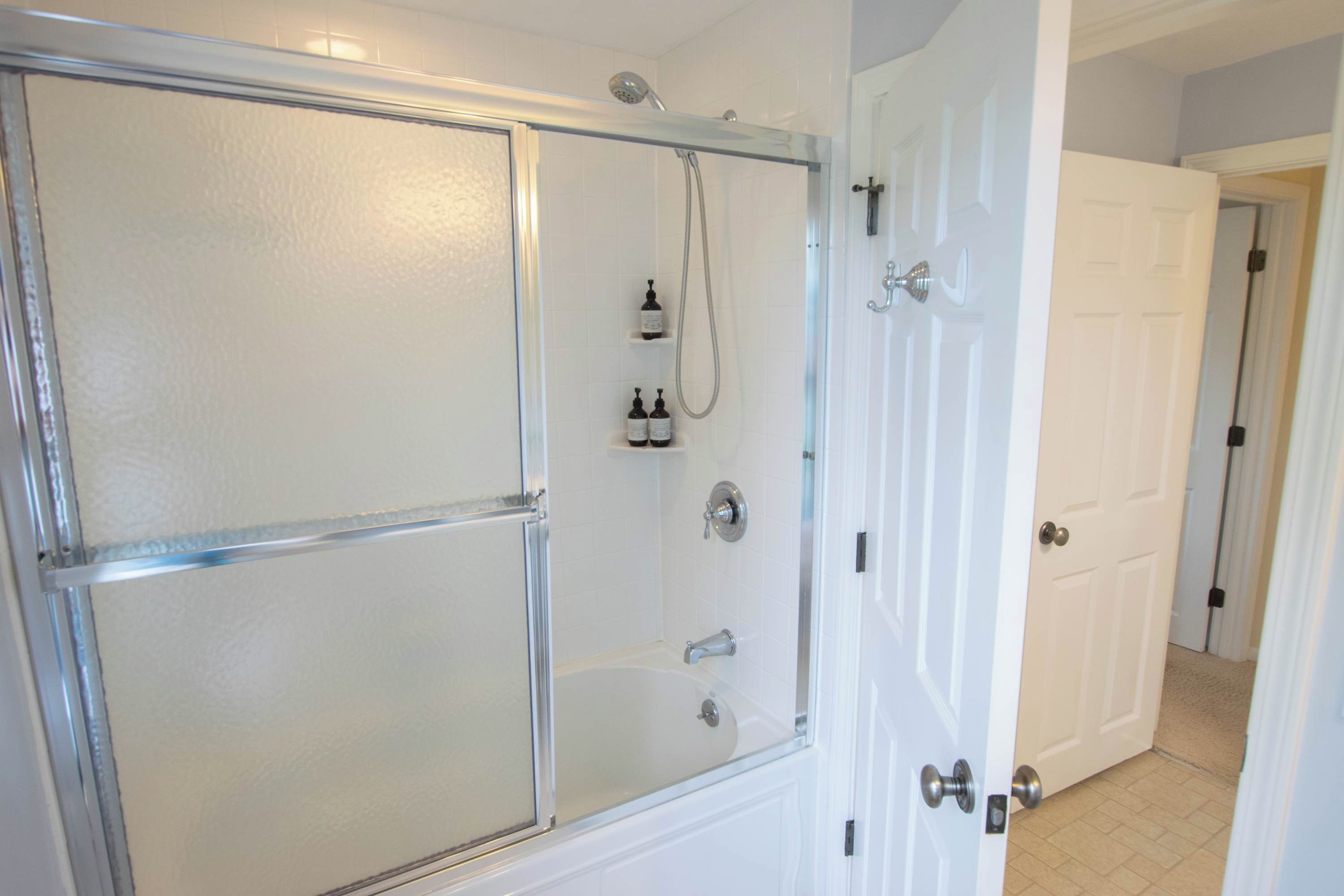 Un baño con cabina de ducha de vidrio, inodoro y lavamanos.