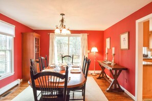A dining room with a wooden table, chairs, and a chandelier. - Beautiful Spacious Family Retreat w/ Pool! (Eastham)